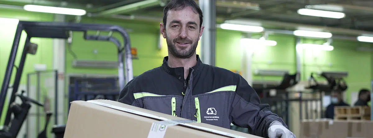 Mecánico con uniforme y una caja de cartón entre las manos