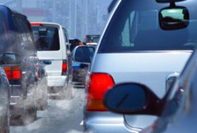 Varios coches en un atasco echando humo blanco por el tubo de escape