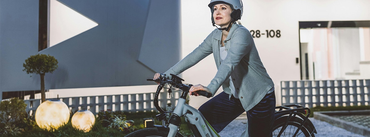 Mujer montada en bicicleta eléctrica con casco