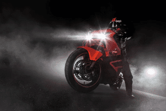 Moto roja por la noche con las luces encendidas